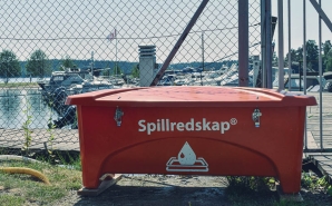 Spillkit med spillredskap, såsom absorbenter och länsor, som står vid båtklubb.